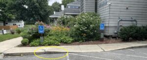 BEFORE - Cracks in sidewalk, non-compliant ramp. Paint peeling and faded on bollards.